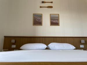 a bed with two white pillows in a room at Apartamento beira-mar in Ilha Comprida