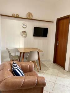 a living room with a couch and a table at Apartamento beira-mar in Ilha Comprida +4 photos