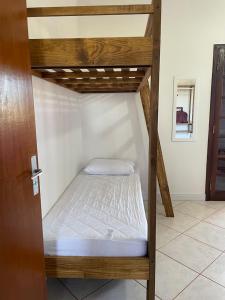 a wooden bunk bed in a room with a door at Apartamento beira-mar in Ilha Comprida