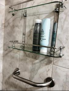 a glass shelf on a bathroom wall with cosmetics at Departamento Parana 2 in Posadas +17 photos