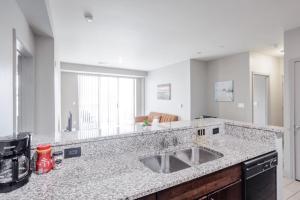 a kitchen with a sink and a large mirror at CozySuites at the Banks gym pool 12 in Cincinnati