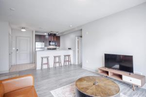 a living room with a table and a kitchen at CozySuites at the Banks gym pool 12 in Cincinnati