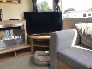 a living room with a tv and a couch and a chair at Cherry, 2 Bed, 6 Berth With Electric Panel Heaters 70724C in Great Yarmouth
