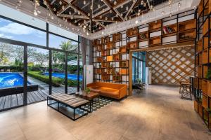 un salon ouvert avec une bibliothèque et une piscine dans l'établissement Roy-Sanya Bay Coconut Dream Corridor, à Shuijiao