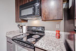 a kitchen with a stove and a microwave at CozySuites at the Banks gym pool 08 in Cincinnati