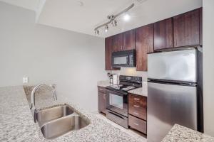 a kitchen with stainless steel appliances and wooden cabinets at CozySuites at the Banks gym pool 08 in Cincinnati +17 photos
