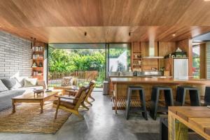 an open kitchen and living room with wooden ceilings at Muli Muli in Ocean Shores