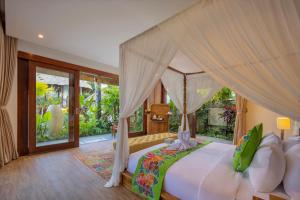 a bedroom with a large bed with a canopy at Villa Lembah Damai by GenuineHost in Gianyar