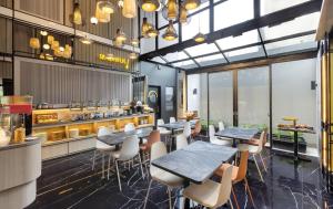 a restaurant with tables and chairs and a counter at ROOMS INC Sudirman Jakarta in Jakarta