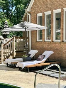 スネルビルにあるCamellias Haven Cozy New Reno 2Bed Apt 40 Min to ATLの家の前にラウンジチェア2脚とパラソル1本