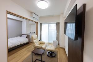 山形市Tomattoco KASUMI的一间带床、电视和椅子的卧室 更多56张照片