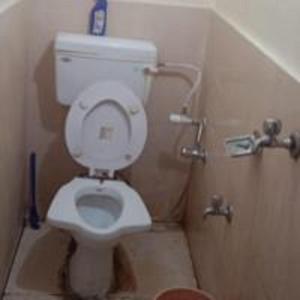 a bathroom with a white toilet in a stall at Dana Pani Homestay by StayApart in Ukhimath