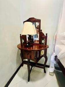 a table with a lamp and a mirror on it at Mbweni Ruins hotel & Appartments in Zanzibar City