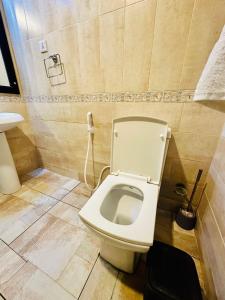 a bathroom with a toilet with a phone on the wall at Mbweni Ruins hotel & Appartments in Zanzibar City