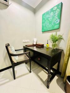 a black desk and a chair in a room at Mbweni Ruins hotel & Appartments in Zanzibar City +3 photos