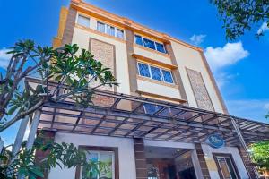 ein hohes Gebäude mit vielen Fenstern in der Unterkunft Hotel O My Home@Bali in Kuta