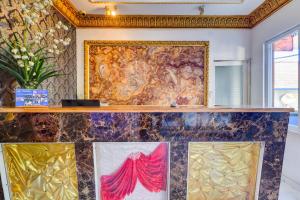 eine Wand mit einem Gemälde neben zwei Gemälden in der Unterkunft Hotel O My Home@Bali in Kuta