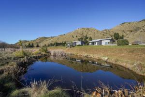 a house on the side of a river at Hurunui River Retreat - Flax Cottage in Hurunui