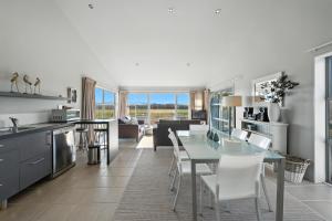 a kitchen and living room with a table and chairs at Hurunui River Retreat - Flax Cottage in Hurunui