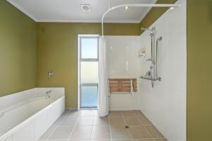 a bathroom with a bath tub and a shower at Hurunui River Retreat - Flax Cottage in Hurunui