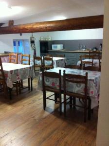 a dining room with tables and chairs and a kitchen at Les Lilas Roses in Chamouilley