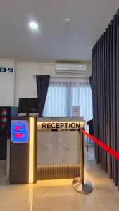 a reception desk in a room with a red ribbon at Berkat Surya Dewa Guest House in Benuaanyar