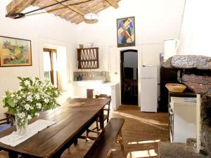 ein Esszimmer mit einem Holztisch und einer Küche in der Unterkunft Rustic apartment with swimming pool in Modigliana