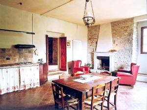 un soggiorno con un tavolo di legno e sedie rosse di Large apartment in a farmhouse a Modigliana