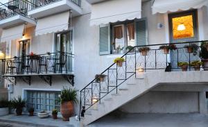 a building with stairs and potted plants on it at Arolithos in Spetses