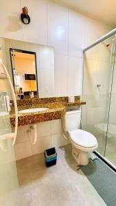 a bathroom with a toilet and a shower and a mirror at Pousada Chamego de Búzios in Buzios