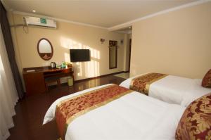 a hotel room with two beds and a desk at GreenTree Inn Jiangsu Huaian Chuzhou Avenue Business Hotel in Huai'an