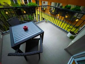 a table with a red bowl on top of a balcony at Apartment Urban Oasis in Olomouc