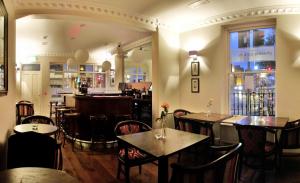 ダブリンにあるフェニックス パーク ホテルのテーブルと椅子のあるレストラン、バー