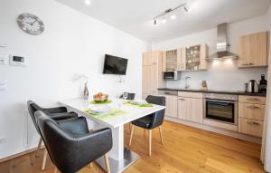 a kitchen with a white table and black chairs at Ferienwohnung Pörtschach in Pörtschach am Wörthersee