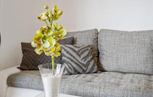 a vase with a flower on a table next to a couch at Ferienwohnung Pörtschach in Pörtschach am Wörthersee +13 photos
