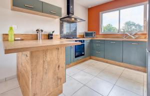 eine Küche mit blauen Schränken und einer Arbeitsplatte in der Unterkunft Charmante Maison À La Campagne in Laveyssière