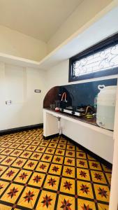 蓬蒂切里Rhythm Stay Pondicherry的厨房设有柜台,铺有黄色和黑色的瓷砖地板。