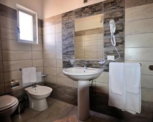 a bathroom with a sink and a toilet and a mirror at Hotel Belvedere Lampedusa in Lampedusa