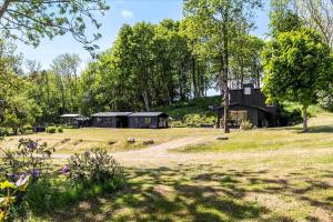 a black house in a field with trees at Beautiful House In Fantastic Surroundings in Nykøbing Mors