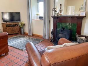 a living room with a couch and a fireplace at The Smiddy in Glasserton