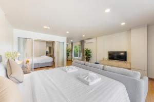 a living room with a white couch and a bed at The Terraza Apartment 2beds B101 in Amphoe Koh Samui
