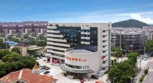 a large building in a city with a lot of buildings at Vienna Hotel Shanghai Songjiang Xiaokunshan in Chengxi