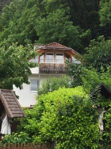 ein Gebäude mit einem Balkon inmitten von Bäumen in der Unterkunft Alexander in Innsbruck