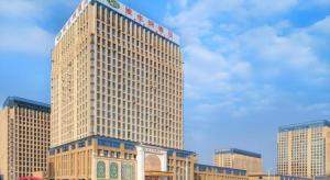 a tall building with a sign on top of it at Vienna Hotel Anhui Fuyang Funan Bailing Apartment in Funan