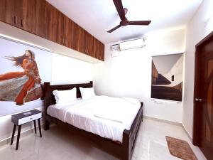 a bedroom with a bed and a ceiling fan at Q by Kolam - Women and Family Serviced Apartments, Thoraipakkam, OMR in Chennai
