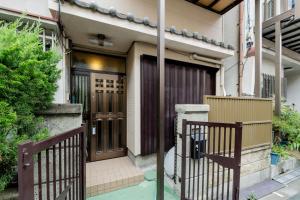 a entrance to a house with a gate at Yoshi do Kulnn2Close to USJ Expo and direct access to Kansai Airport Kyocera Sports Museum Namba吉徳家庭旅館2近USJ空庭菓匠温泉萬博会海游館難波梅田關西空港直達京セラドーム in Osaka
