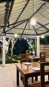 a dining area with tables and chairs under a tent at Pinnacle Safari Resort in Udawalawe