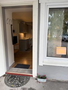 an open door of a house with a kitchen at Lägenhet med sovalkov in Sundsvall