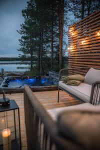une terrasse avec un banc et un bain à remous avec lumières dans l'établissement Arctic Snow Lake Mini Lodge, à Rovaniemi 19 autres photos