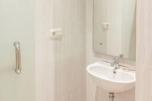 巨港TwoSpaces Living at KR Hotel的一间白色浴室，配有洗手池和镜子。